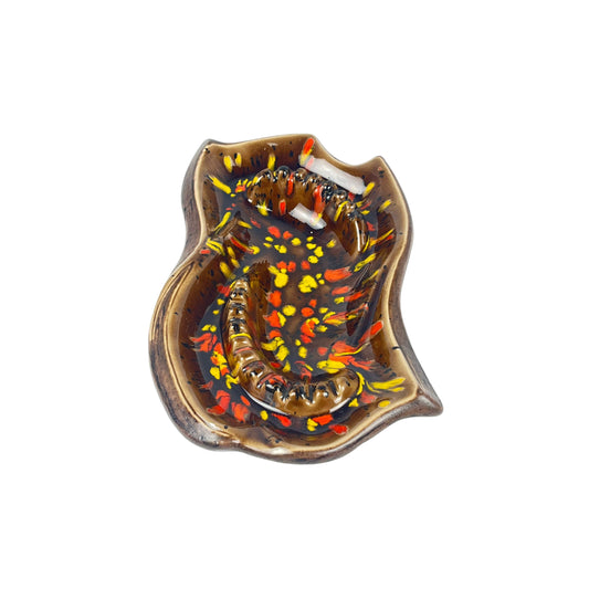 Front view of a vintage decorative ceramic ashtray with artistic design, with shades of orange, yellow, and brown on a white background