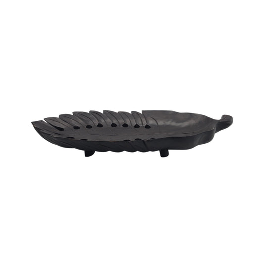 Side view of a large wooden tray with a carved philodendron leaf on a white background