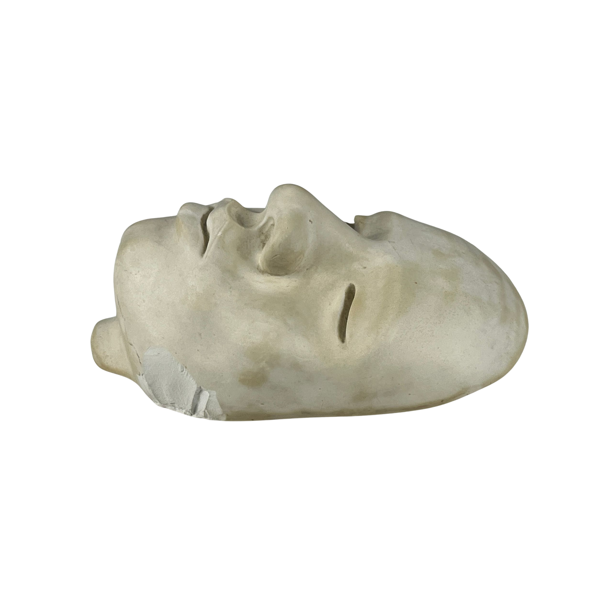 Side view of a plaster sculpture of a face on a white background