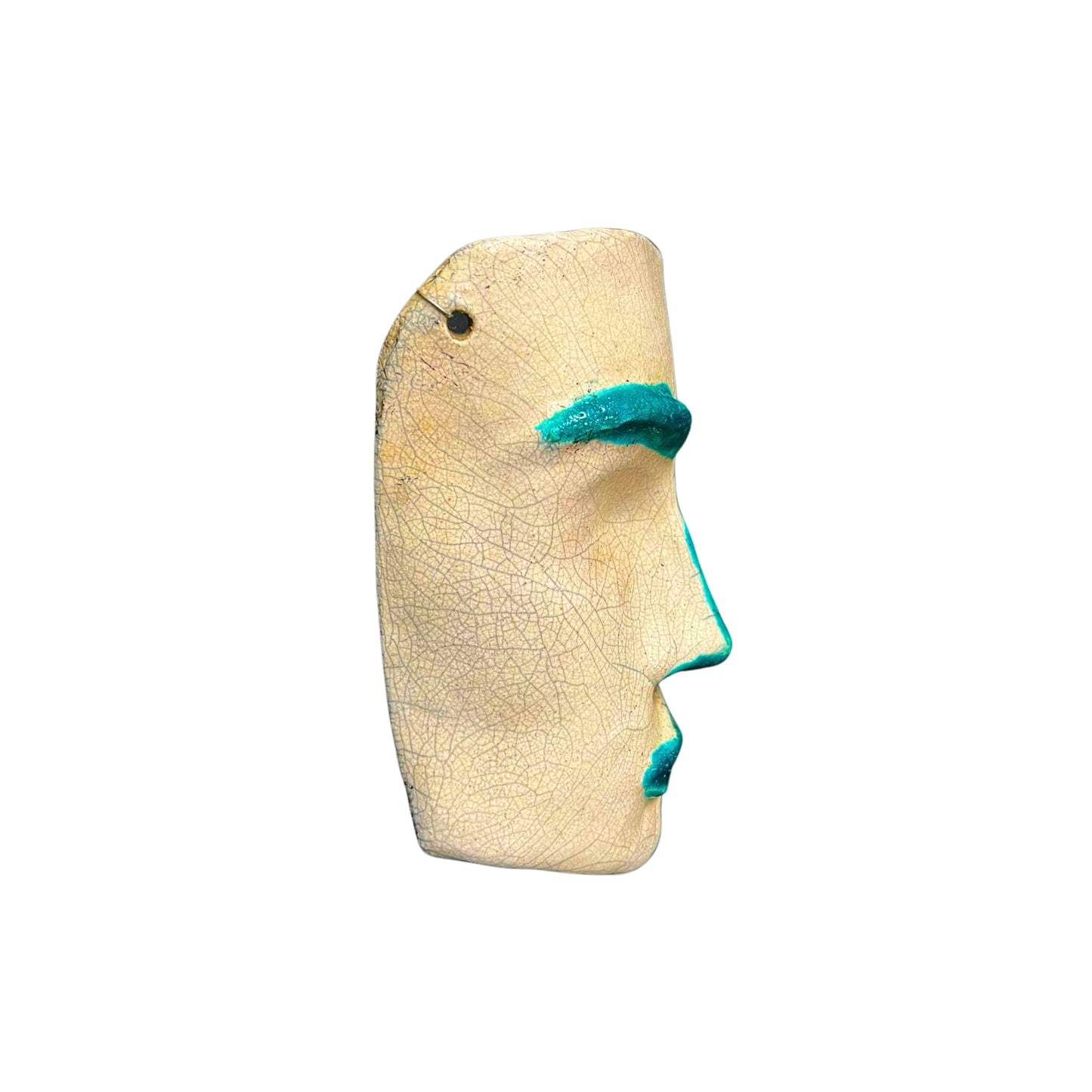 Side view of a ceramic face sculpture with teal accents on a white background