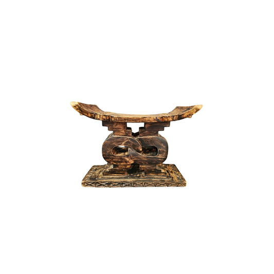 Take a trip back in time with our Vintage Carved Wood Ashanti Stool. This unique piece was crafted in Ghana during the 1950s era and showcases the rich history and culture of the African Ashanti tribe. Every groove and curve on this stool tells a story, making it a perfect addition to any home looking to embrace adventure and take a risk with their decor. Transport your space to a whole new level of boldness and style with this one-of-a-kind piece!
