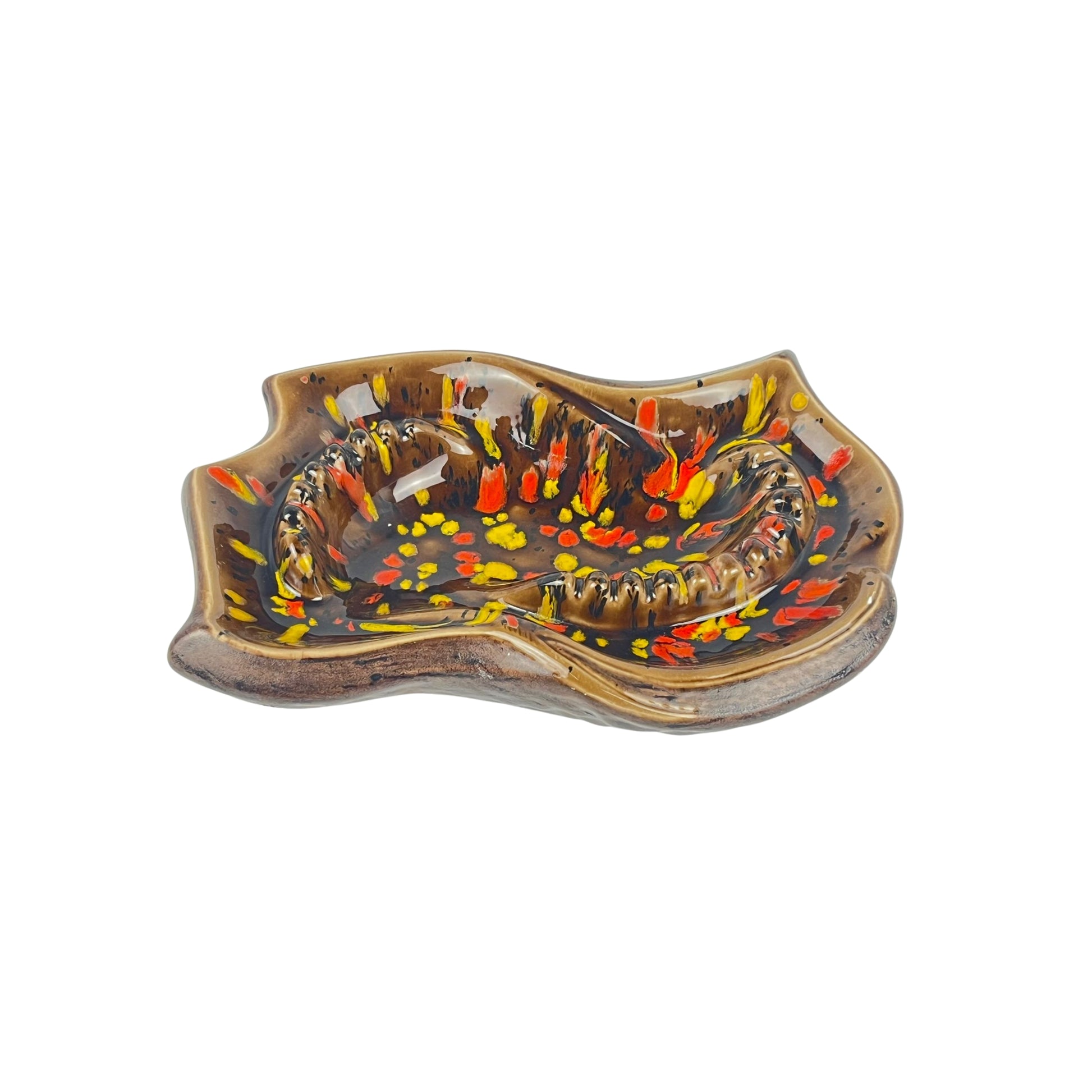 Vintage decorative ceramic ashtray with artistic design, with shades of orange, yellow, and brown on a white background