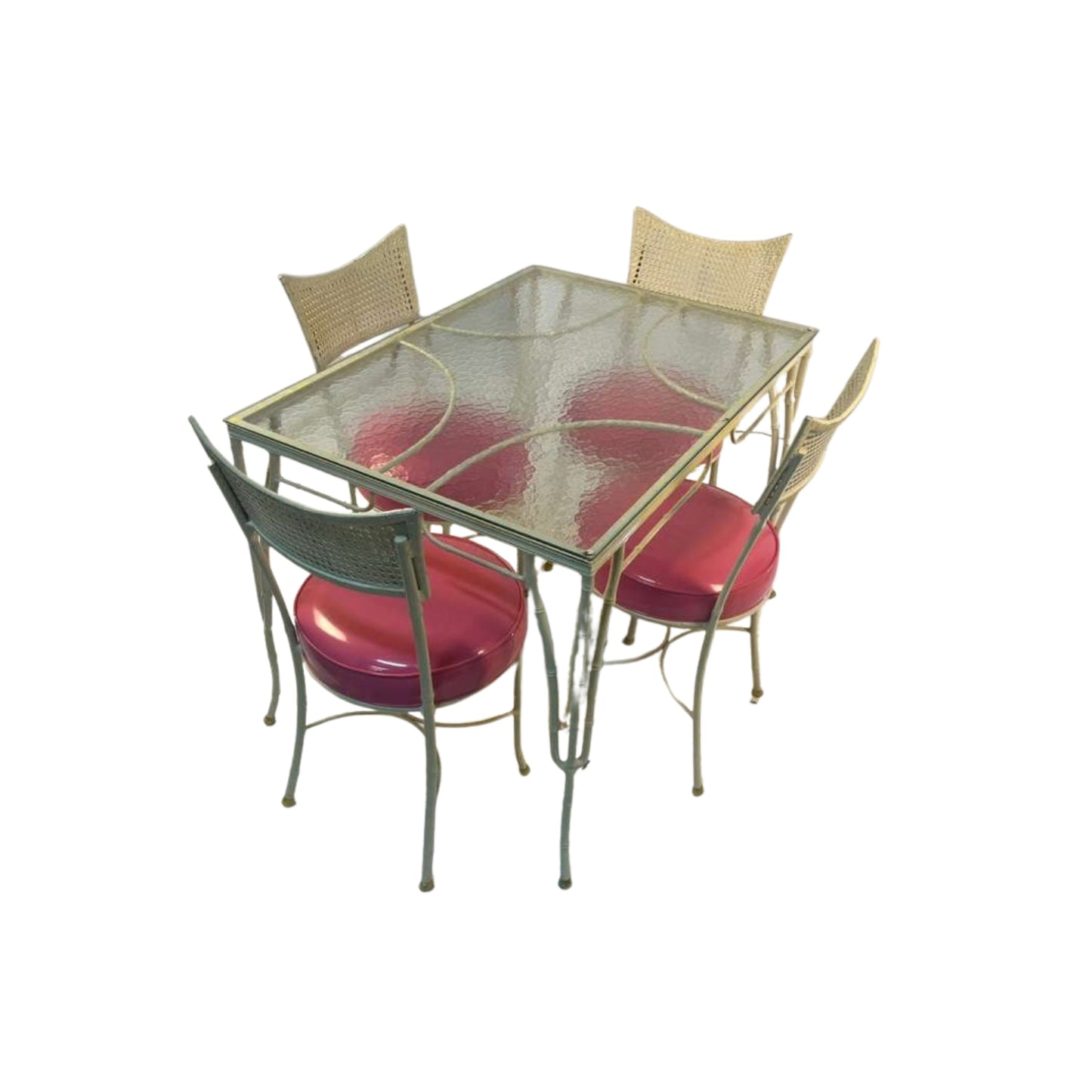 Side view of a 1950s table and 4 iron chairs with rattan and bamboo imitation in pink vegan leather on a white background
