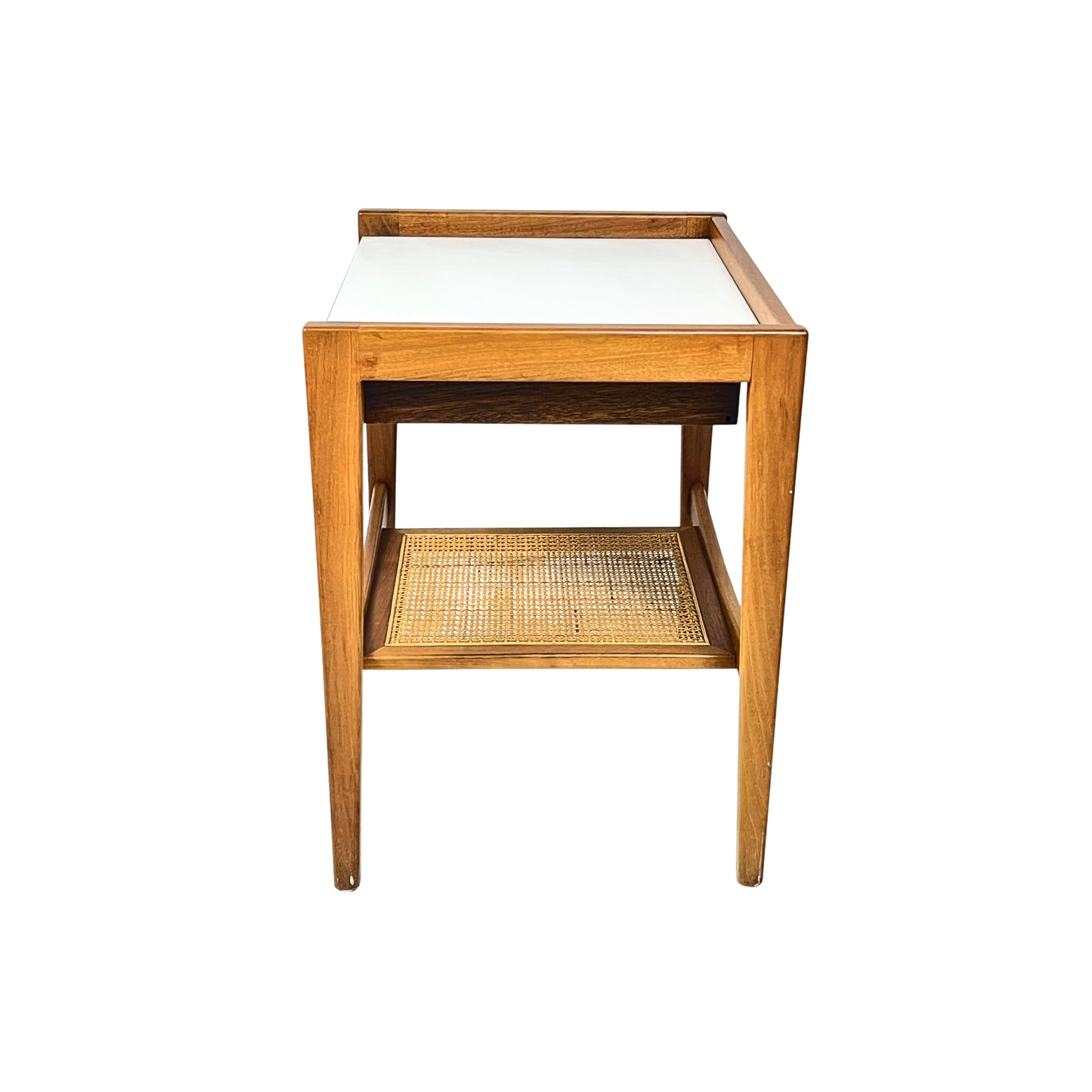 side view of a wooden side table with a white top and a wicker shelf on a white background
