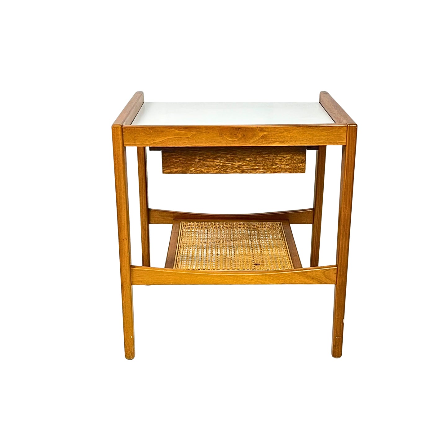 Back view of a wooden side table with a white top and a wicker shelf on a white background