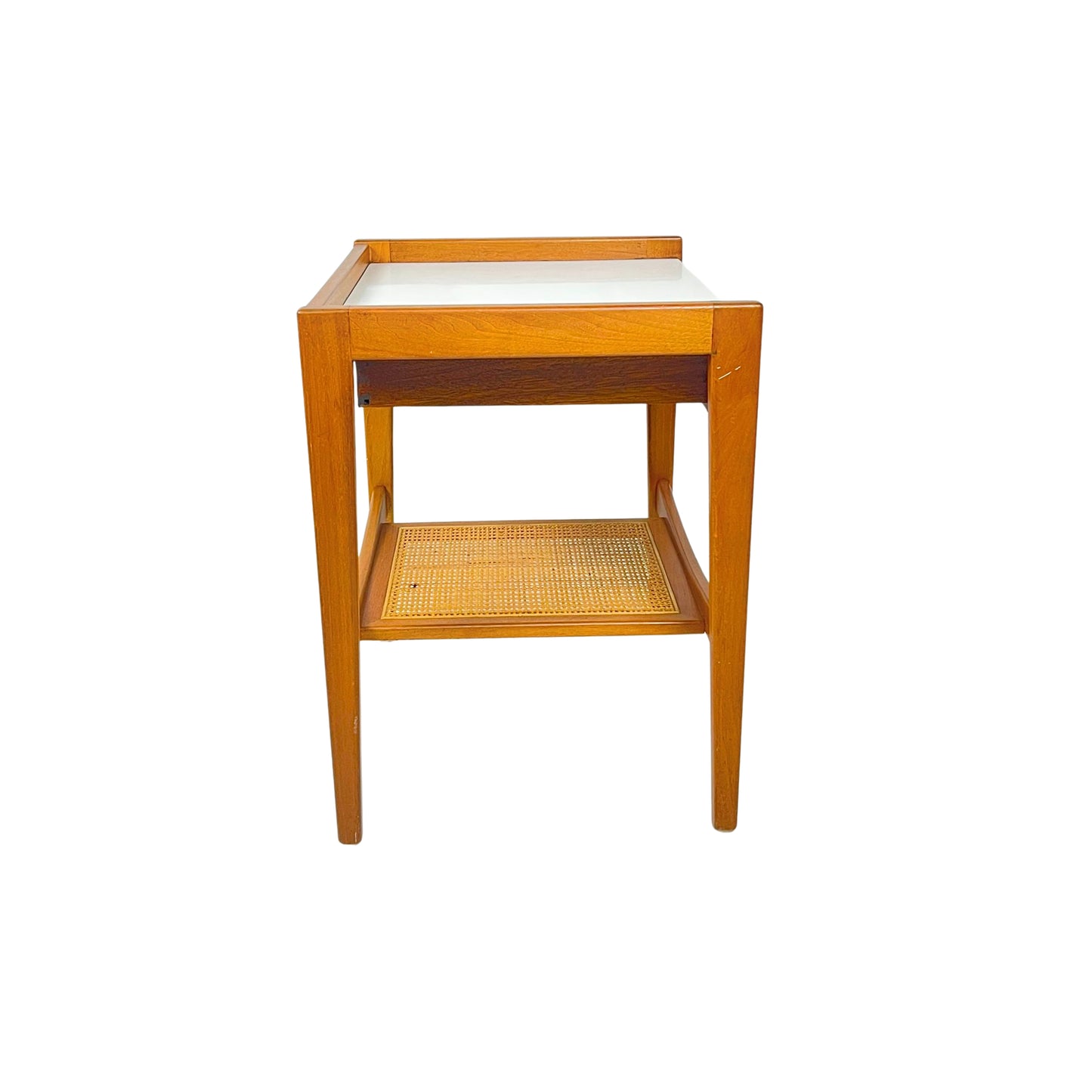 side view of a wooden side table with a white top and a wicker shelf on a white background