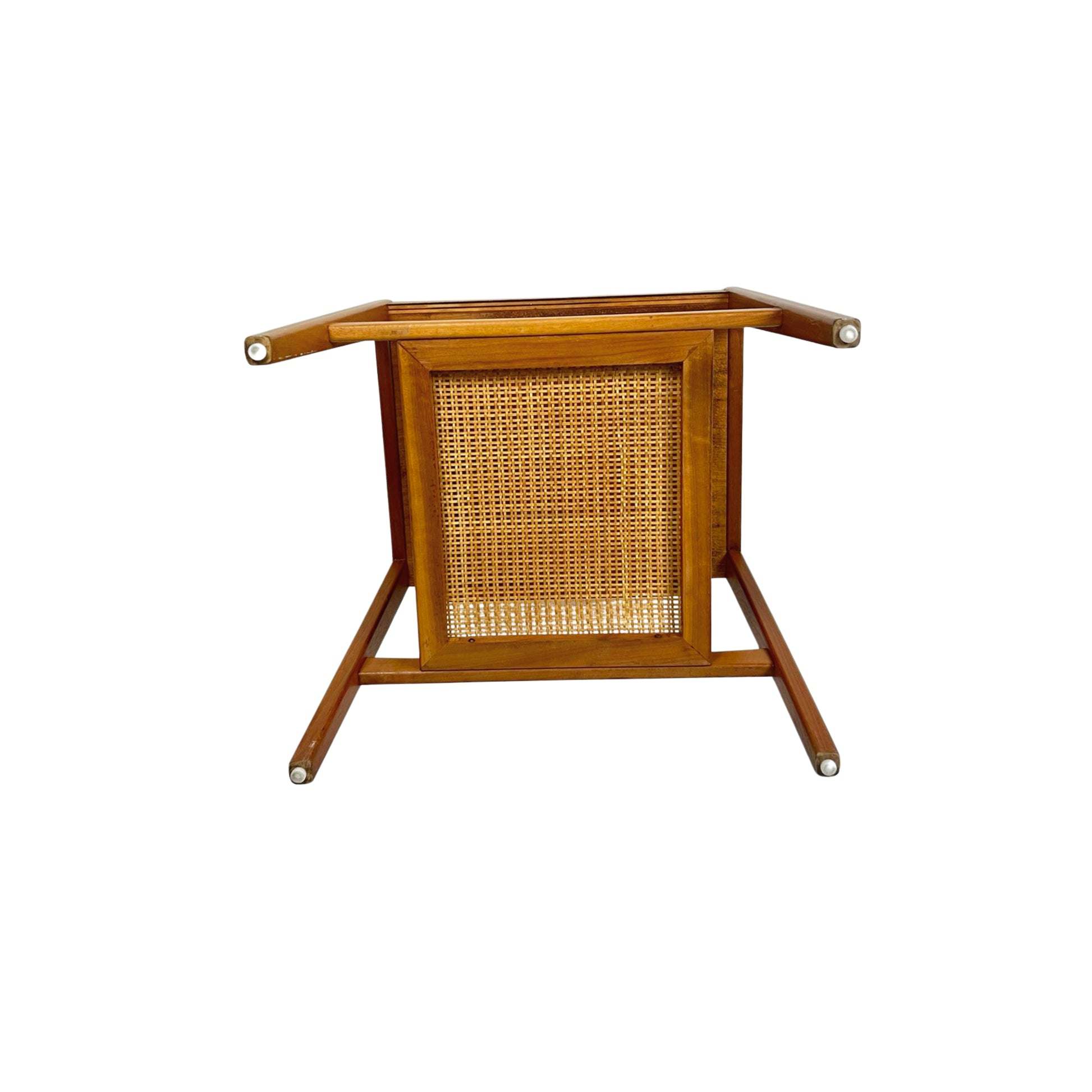 Bottom view of a wooden side table with a white top and a wicker shelf on a white background