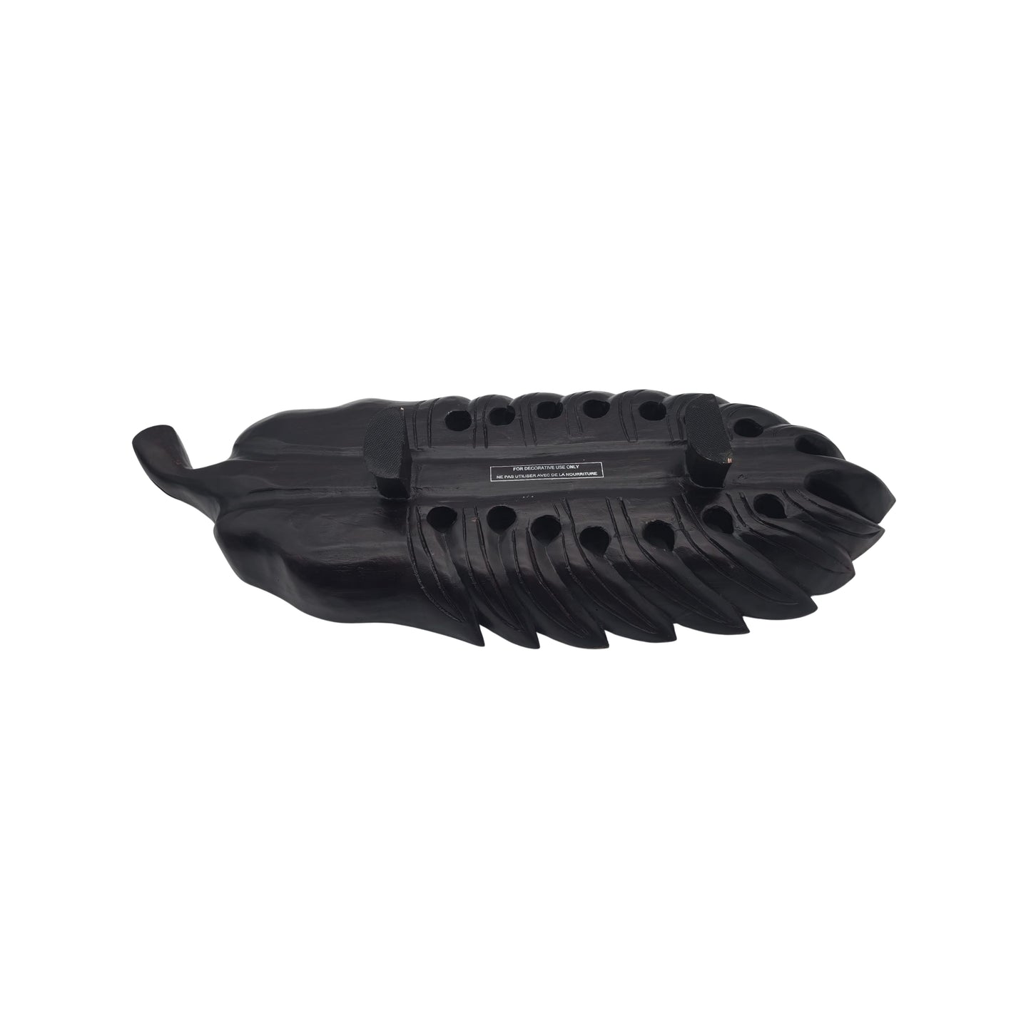 Bottom view of a large wooden tray with a carved philodendron leaf on a white background