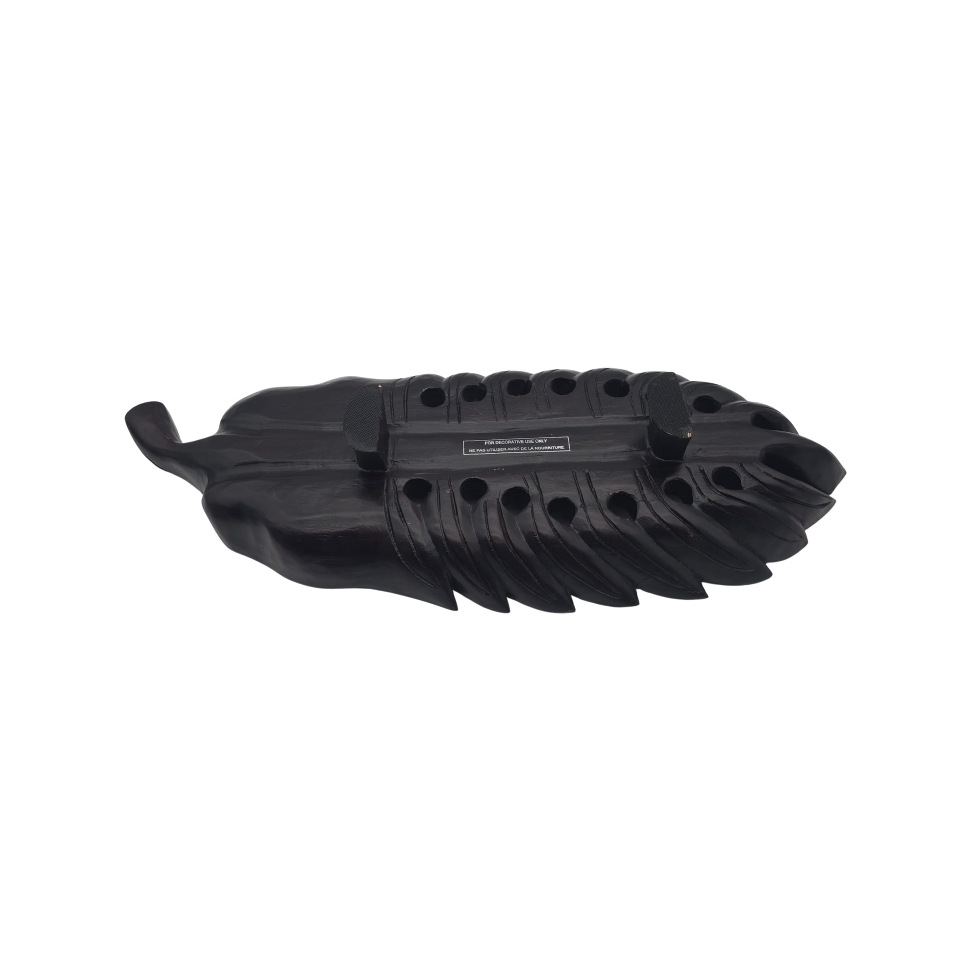 Bottom view of a large wooden tray with a carved philodendron leaf on a white background