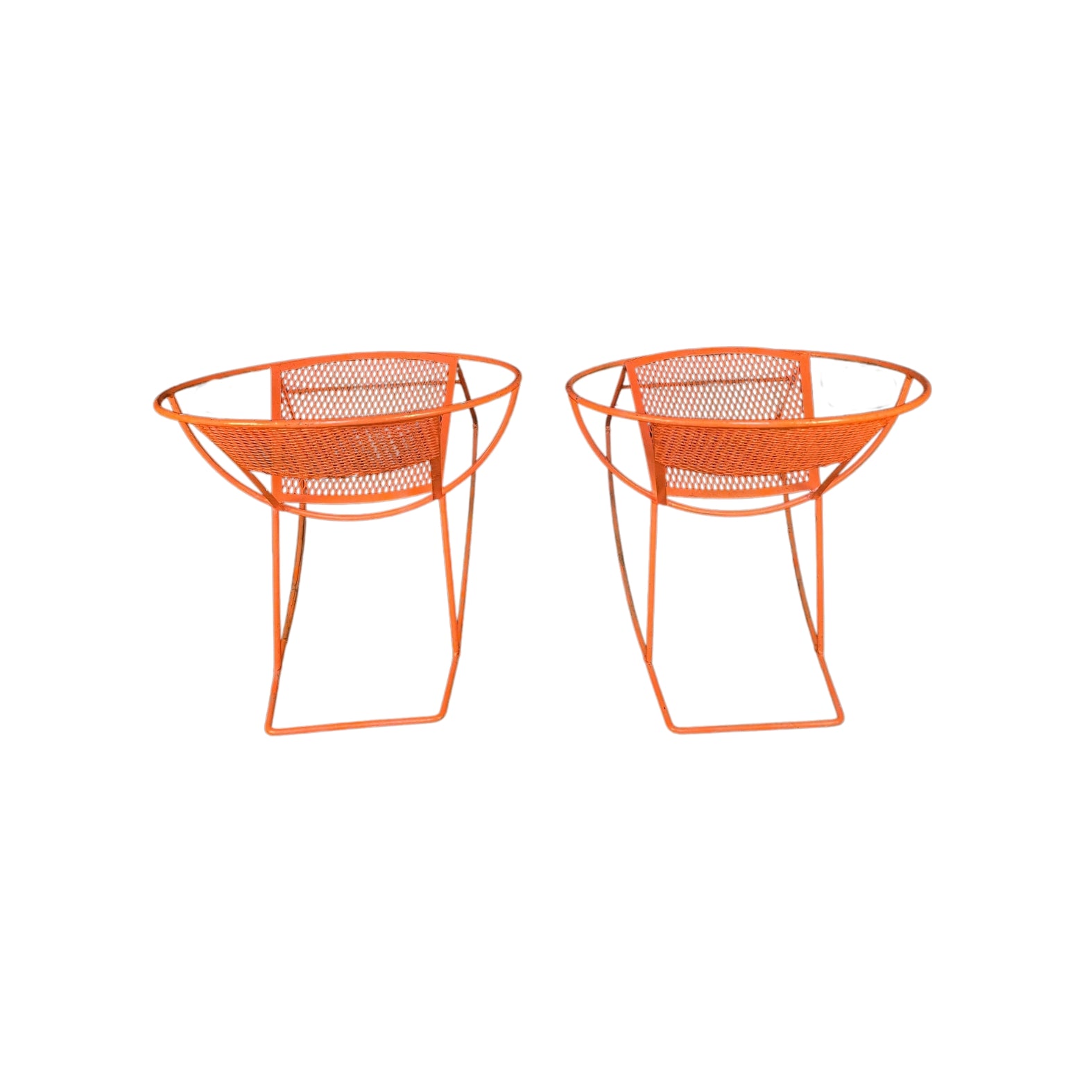 Back view of two orange wrought iron rocking chairs on a white background