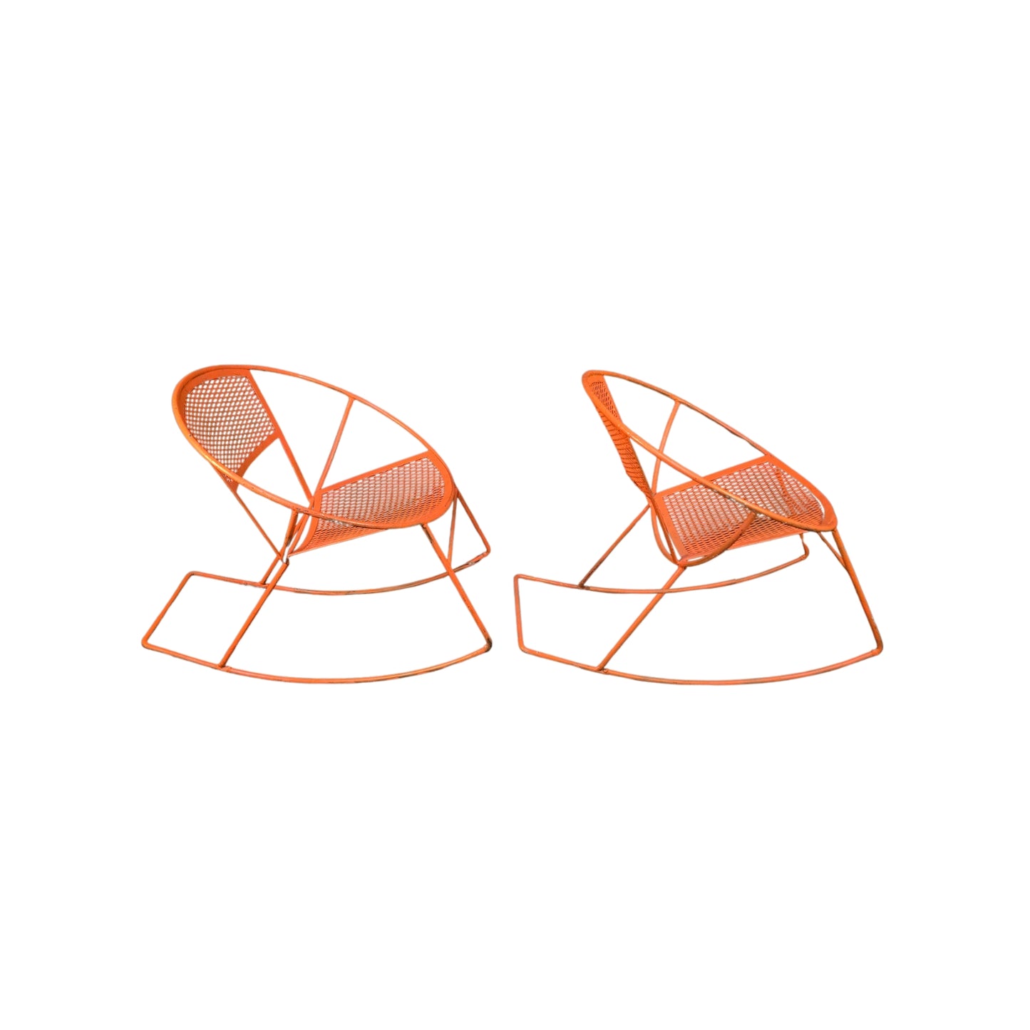 Side view of two orange wrought iron rocking chairs on a white background