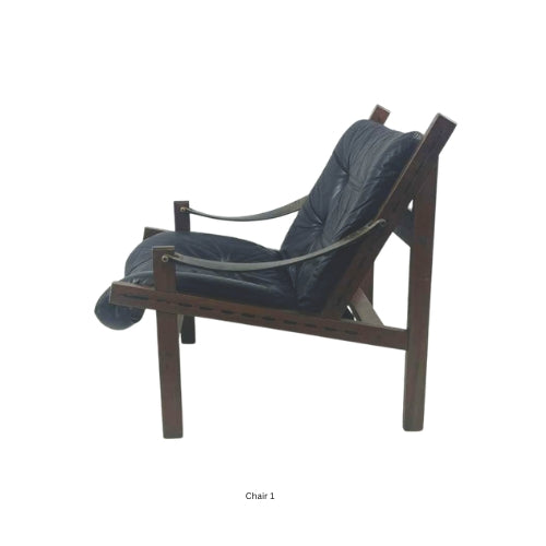 Side view of a vintage mid‑century modern lounge chair with dark tufted leather cushions and a sculpted wooden frame