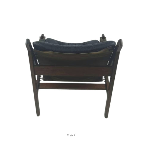 Back view of a vintage mid‑century modern lounge chair with dark tufted leather cushions and a sculpted wooden frame