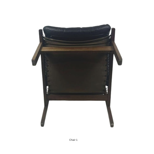 Bottom view of a vintage mid‑century modern lounge chair with dark tufted leather cushions and a sculpted wooden frame
