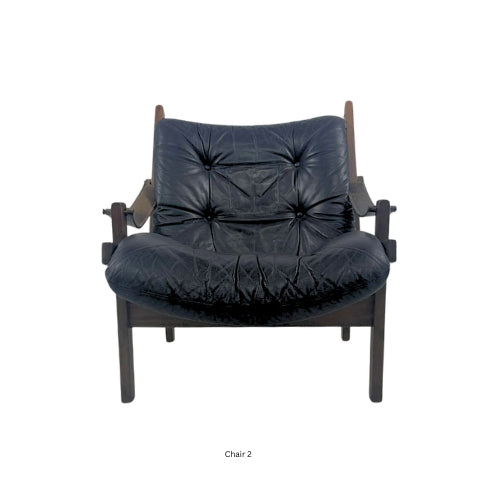 Front view of a vintage mid‑century modern lounge chair with dark tufted leather cushions and a sculpted wooden frame
