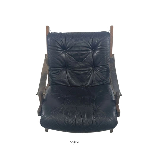 Front view of a vintage mid‑century modern lounge chair with dark tufted leather cushions and a sculpted wooden frame