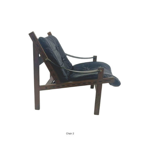 Side view of a vintage mid‑century modern lounge chair with dark tufted leather cushions and a sculpted wooden frame