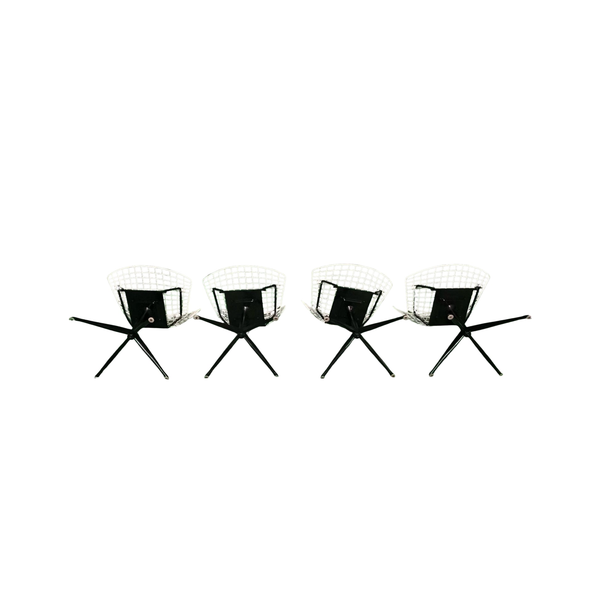 Bottom view of 4 white wrought iron chairs on a white background