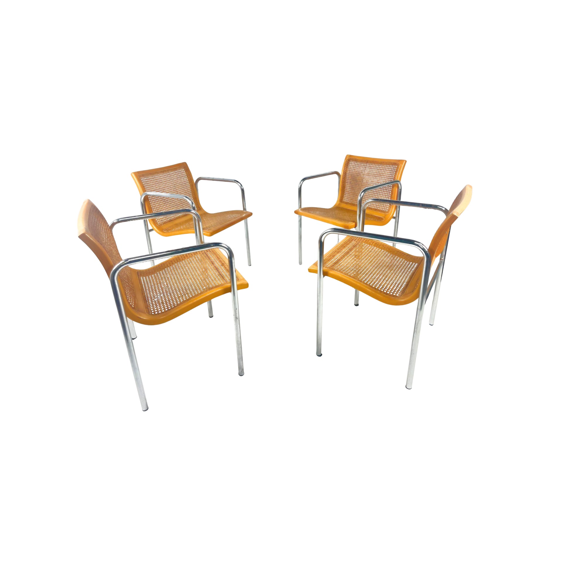 Four natural wood-colored and cesca chairs with metal frames on a white background